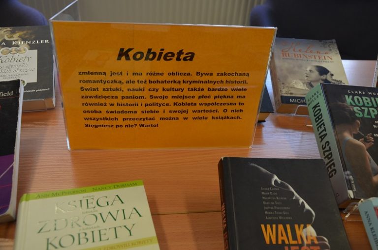 Na stolikach wystawa książek o kobietach z kartką opisującą kobiety