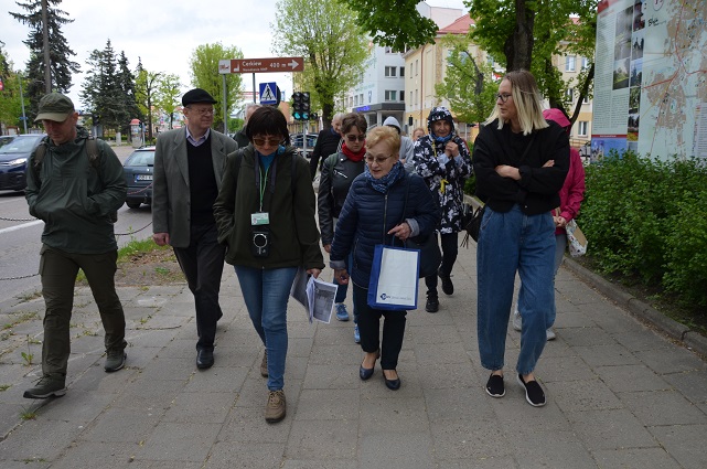 . Grupa osób idących za przewodniczką ulicą Mickiewicza