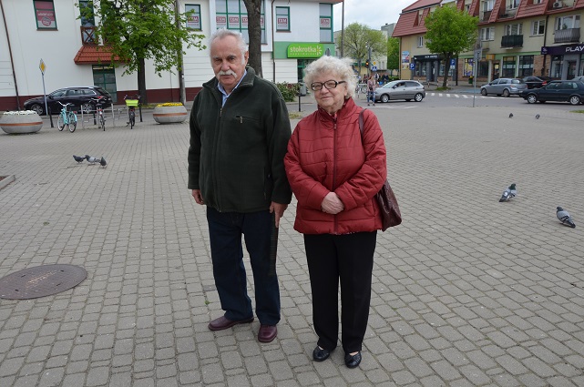 Mężczyzna i kobieta w starszym wieku pozują do zdjęcia na placu przy ratuszu