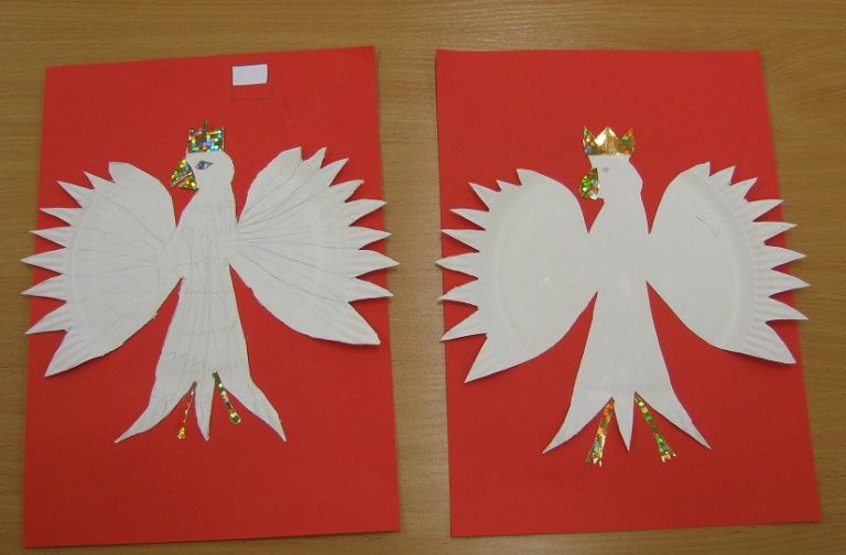 Na fotografii dwie prace plastyczne ułożone na stole, przedstawiające Orła Białego wykonanego papieru ułożonego na czerwonej kartce.