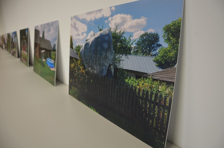 Obrazy Magdy Sobczak ustawione na półce przy ścianie.