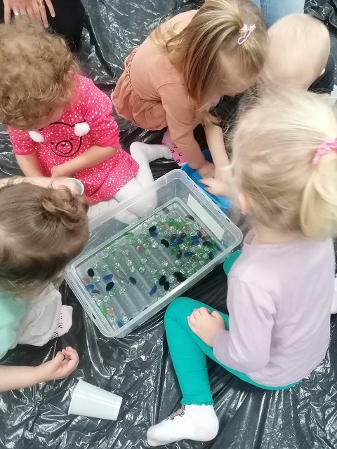 Czwórka dzieci przy pudełku z kolorowymi kamieniami